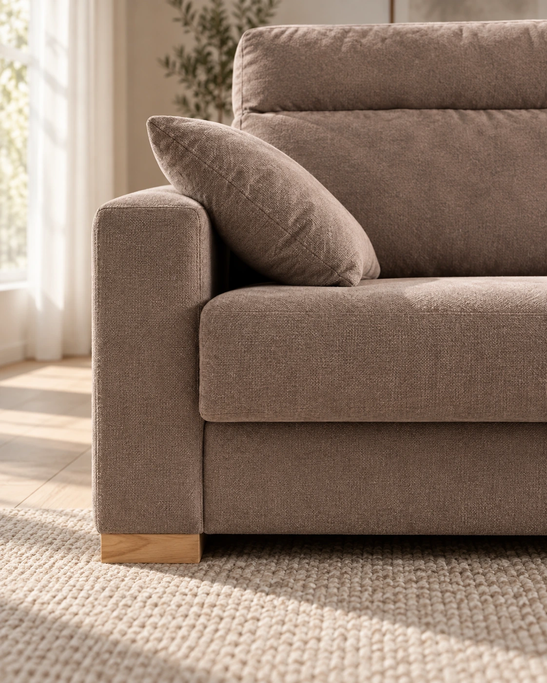Detalle de la pata baja de madera y la tapicería taupe del sofá Alba.