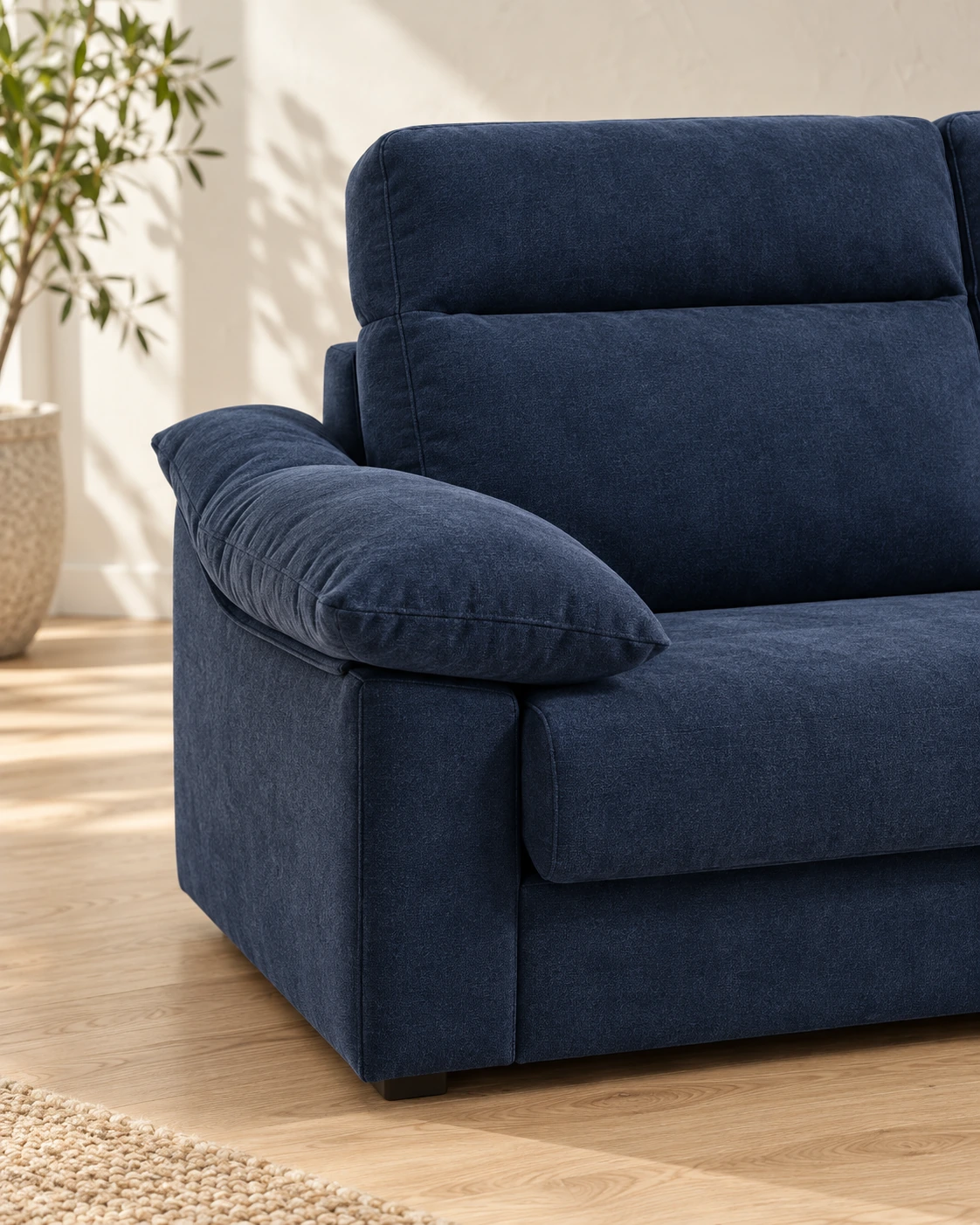 Detalle del brazo acolchado, el asiento y el respaldo alto del sofá cama Nara en azul navy.