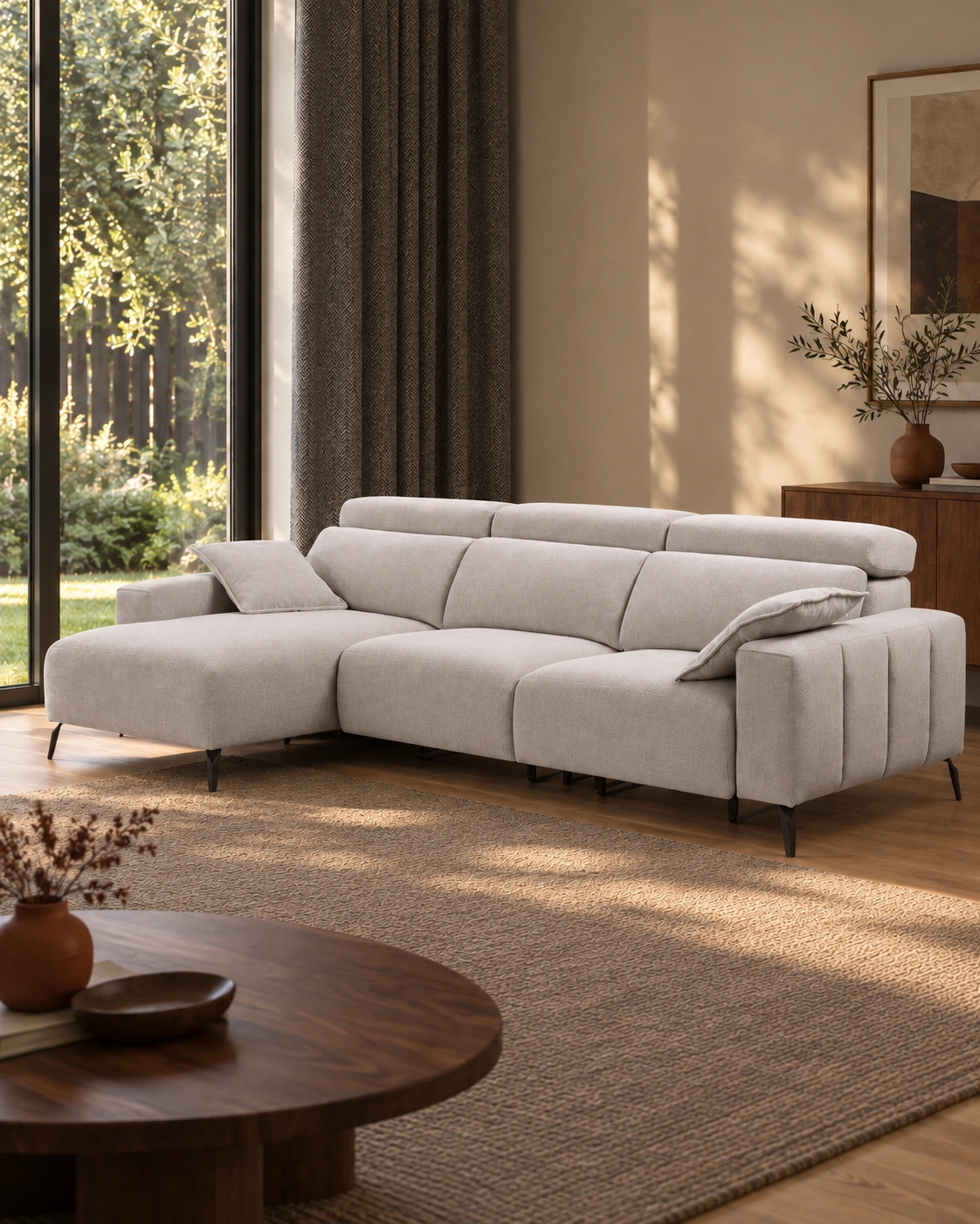 Sofá Valeria beige con chaise longue a la izquierda en un salón con ventanal, madera oscura y detalles terracota